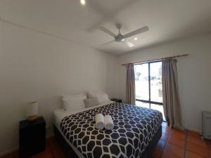a bedroom with a bed with a black and white comforter at Blue Oasis in Esperance