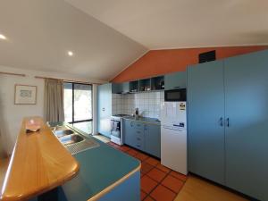 a kitchen with blue cabinets and a counter top at Blue Oasis in Esperance
