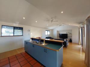 a kitchen with a sink and a living room at Blue Oasis in Esperance +4 photos