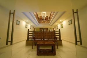 a sanctuary with a bench in the middle of a room at Velan Temple View in Palni