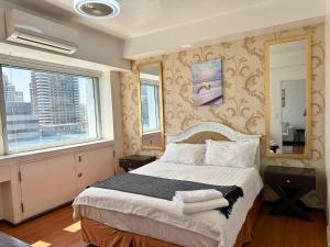 a bedroom with a bed and a large window at Grand Cenia Residences in Cebu City