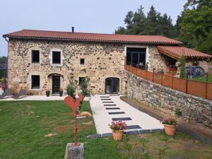 a stone house with a pathway in front of it at La Clef des songes in Lafarre
