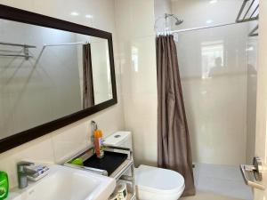 a bathroom with a toilet and a sink and a mirror at Grand Cenia Residences in Cebu City