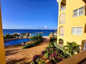 a view of the ocean from the balcony of a building at Beach House The Strand in Willemstad