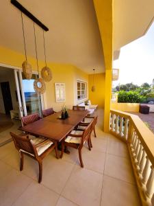 a dining room with a wooden table and chairs at Beach House The Strand in Willemstad
