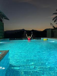 a person in a large swimming pool with water at Lazo EcoSpot Vythiri , Wayanad in Vythiri