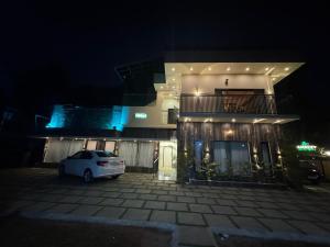 a white car parked in front of a building at night at Lazo EcoSpot Vythiri , Wayanad in Vythiri +2 photos