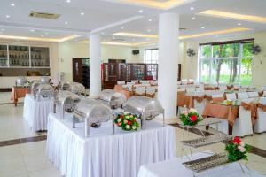 a banquet hall with white tables and chairs at Hải Tiến Resort in Mỹ Ðuc