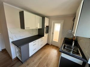 a small kitchen with white cabinets and a sink at Ferienwohnung am Nürburgring in Herresbach