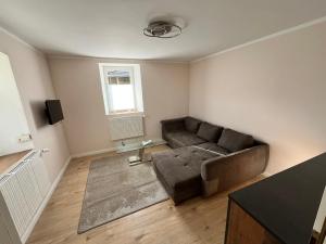 a living room with a couch and a window at Ferienwohnung am Nürburgring in Herresbach