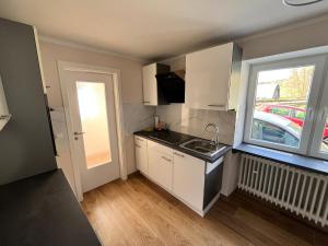 a small kitchen with a sink and a window at Ferienwohnung am Nürburgring in Herresbach +12 photos