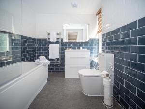 a bathroom with a tub and a toilet and a sink at The Crown in Poole +19 photos