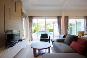 a living room with a couch and a tv and a table at Luxury House in Hua Hin in Khao Tao