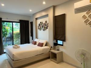 a bedroom with a bed with a fan and a window at Duangtham luxury Pool Villa in Ban Khlong Haeng +19 photos