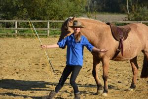 a woman in a hat standing next to a horse at Bienvenu dans le Java chez Pommes & Chevaux in Favières