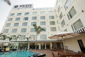 a hotel with a swimming pool in front of a building at ARISTA BY AMBITION in Guwahati