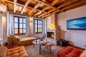a living room with a fireplace and a tv at Meliades Luxury Villas in Arachova