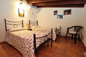 a bedroom with two beds and a chair at Villa Salvatore in San Leone +37 photos