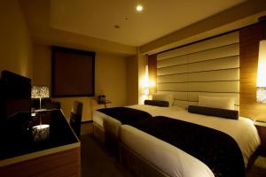 a hotel room with a large bed and a television at Hotel Trusty Osaka Abeno in Osaka