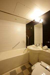 a bathroom with a toilet and a sink and a tub at Hotel Trusty Osaka Abeno in Osaka
