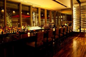 a bar with chairs in a room with wine bottles at Hotel Trusty Osaka Abeno in Osaka