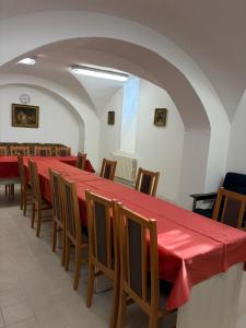 a long table with chairs and a red table cloth at Koleje Zámeček in Lednice