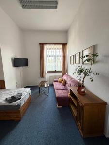 a bedroom with a bed and a couch and a table at Koleje Zámeček in Lednice