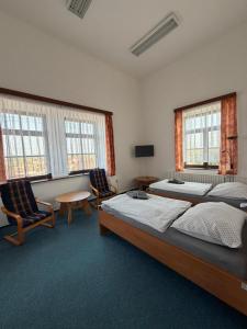 a bedroom with two beds and two chairs and windows at Koleje Zámeček in Lednice +43 photos