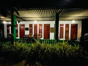 a building with wooden doors and chairs and plants at Jm Resort in Dambulla