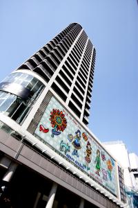 a large building with a clock on the top of it at Hotel Trusty Osaka Abeno in Osaka