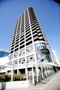 a tall white building with a sign on it at Hotel Trusty Osaka Abeno in Osaka