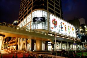a large building with a sign on it at night at Hotel Trusty Osaka Abeno in Osaka