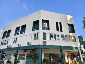 a white building with windows on a street at Sunstone Hotel in George Town