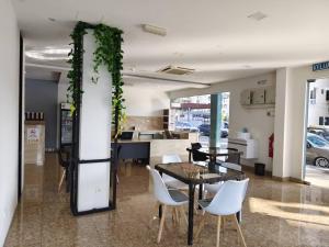 a dining room with a table and white chairs at Sunstone Hotel in George Town