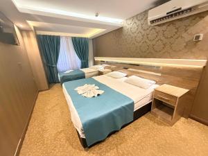 a hotel room with two beds and a blue blanket at Rain Golden Hotel in Istanbul