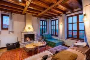 a living room with a couch and a fireplace at Meliades Luxury Villas in Arachova