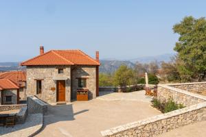 a stone house with a stone wall and a patio at Meliades Luxury Villas in Arachova