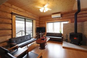 a living room with a couch and a fireplace at ヴィラ湖西 最大11名 琵琶湖ビュー165平米の一棟貸切ログハウス BBQハウス完備 広々3LDK ロフト Wi-Fi in Takashima