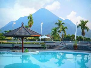 a swimming pool with a mountain in the background at Grand Whiz Hotel Trawas Mojokerto in Trawas