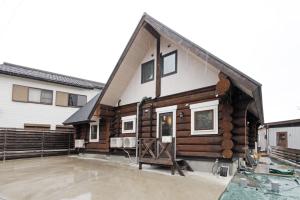 a house with a gambrel roof on a patio at ヴィラ湖西 最大11名 琵琶湖ビュー165平米の一棟貸切ログハウス BBQハウス完備 広々3LDK ロフト Wi-Fi in Takashima