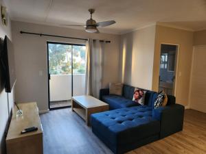 a living room with a blue couch and a table at Manchester Heights in Cape Town