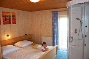 a little girl laying on a bed in a bedroom at Grasreithof in Grossarl