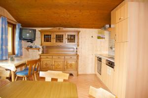a kitchen with wooden cabinets and a table and a tv at Grasreithof in Grossarl