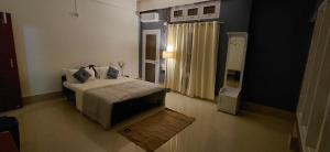 a bedroom with a bed and a door to a window at Pipitsnest 2 homes in Tezpur +7 photos