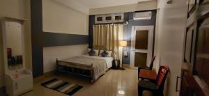 a small bedroom with a bed and a chair at Pipitsnest 2 homes in Tezpur