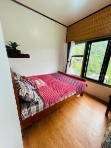 a bed in a room with a large window at Batad Pension Ph in Banaue +36 photos