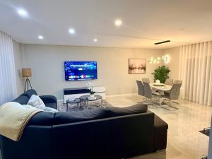 a living room with a couch and a dining room at Modern Villa near Lisbon & Beaches with Heated Pool in Fernao Ferro