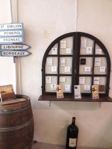 a shelf with a bottle of wine and a barrel at chambre Médoc du Logis du Parc in Libourne +12 photos