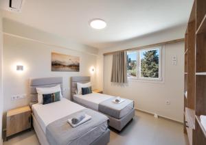 a hotel room with two beds and a window at Asmira Apartments in Lygia
