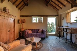 a living room with a purple couch and a table at Bed & Breakfast De Tol in Sint Annaland